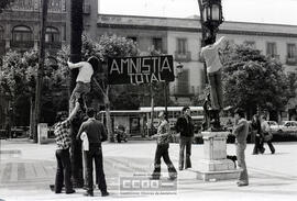 Jóvenes colgando el cartel "Amnistía total" en la plaza Nueva – Foto 1